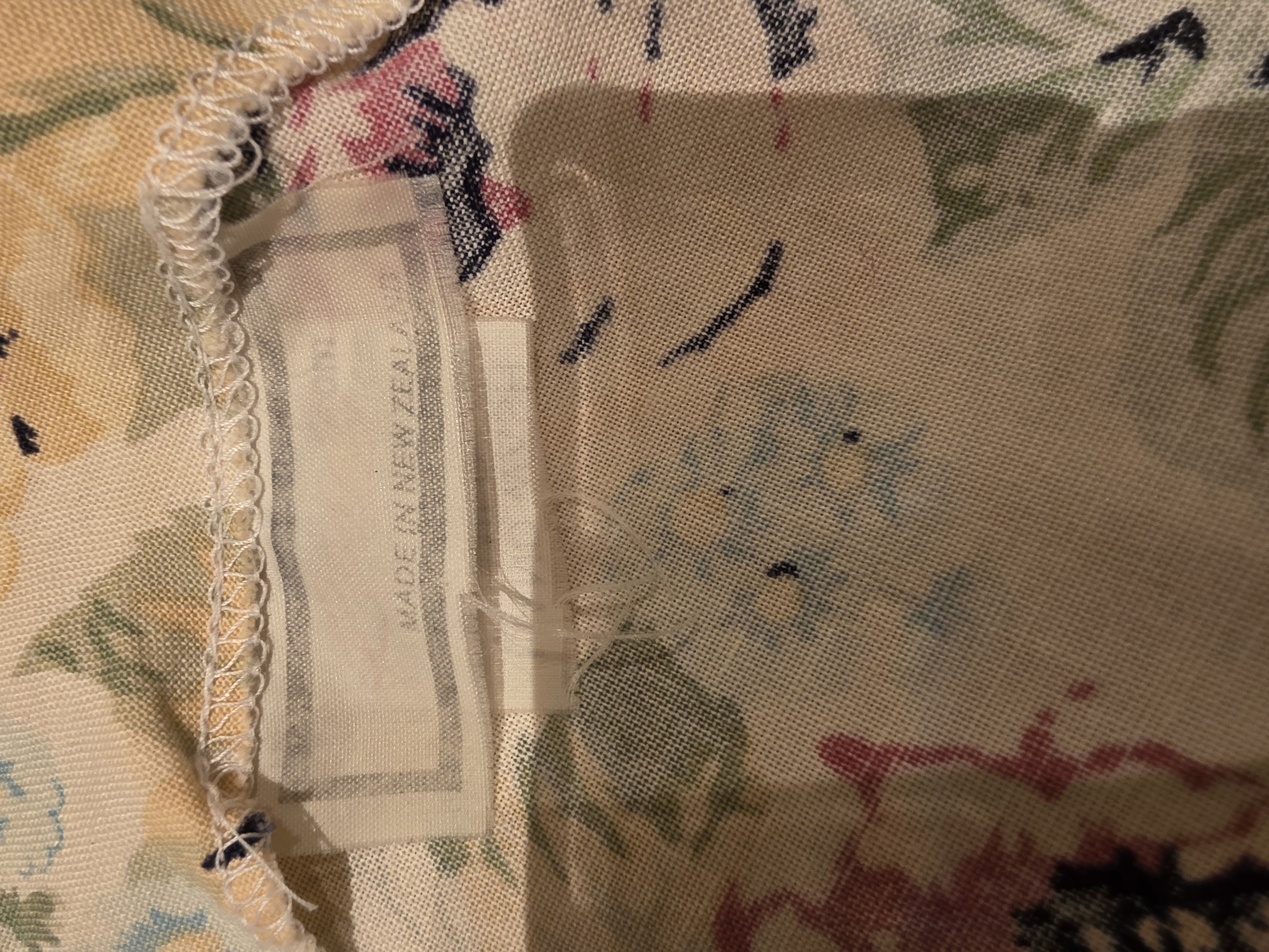 Close view of the dress’s faded fabric label with the words Made in New Zealand still visible