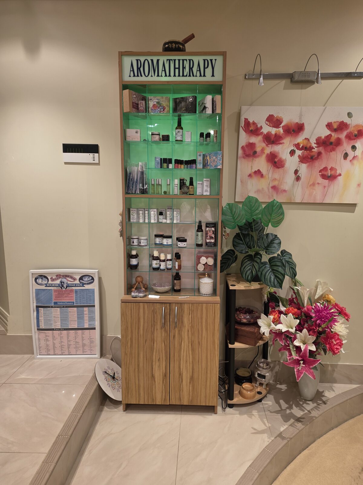 An Amor Aromatherapy display finding its place in the new home, with products, flowers and a painting